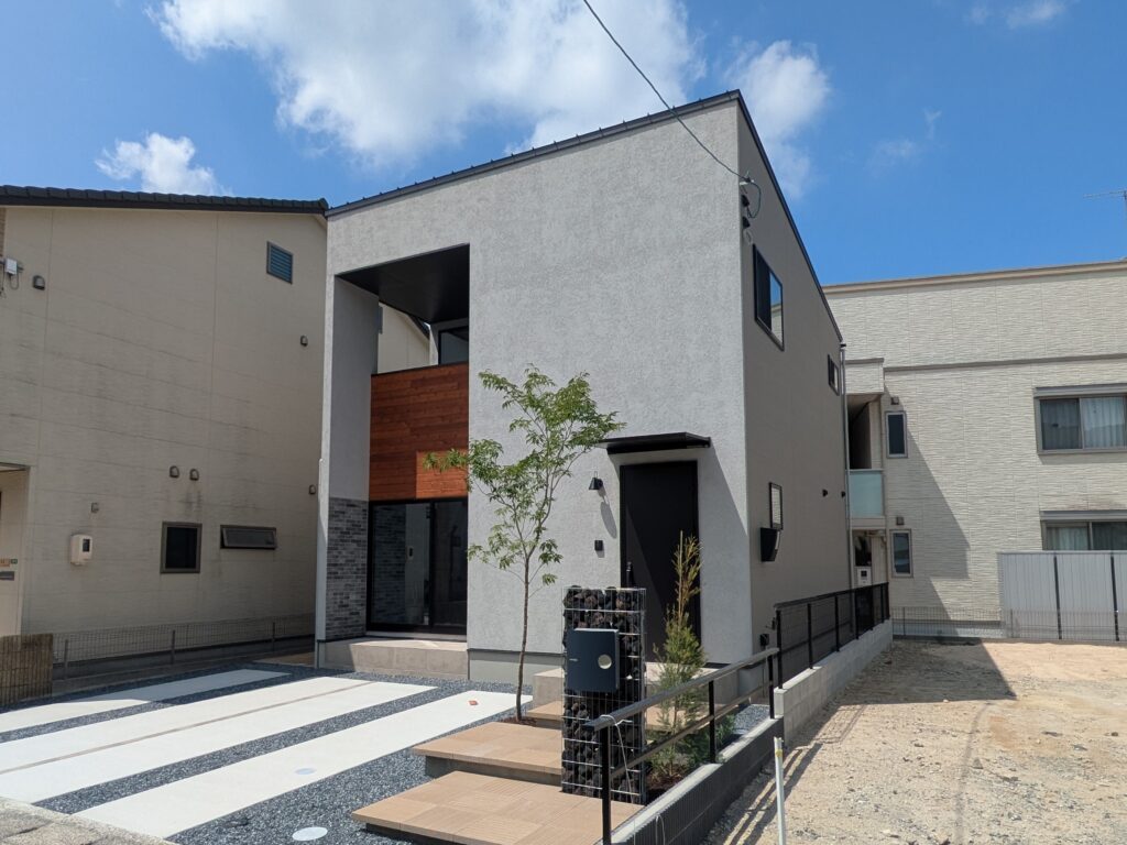 塗り壁と植栽の緑が調和する外観